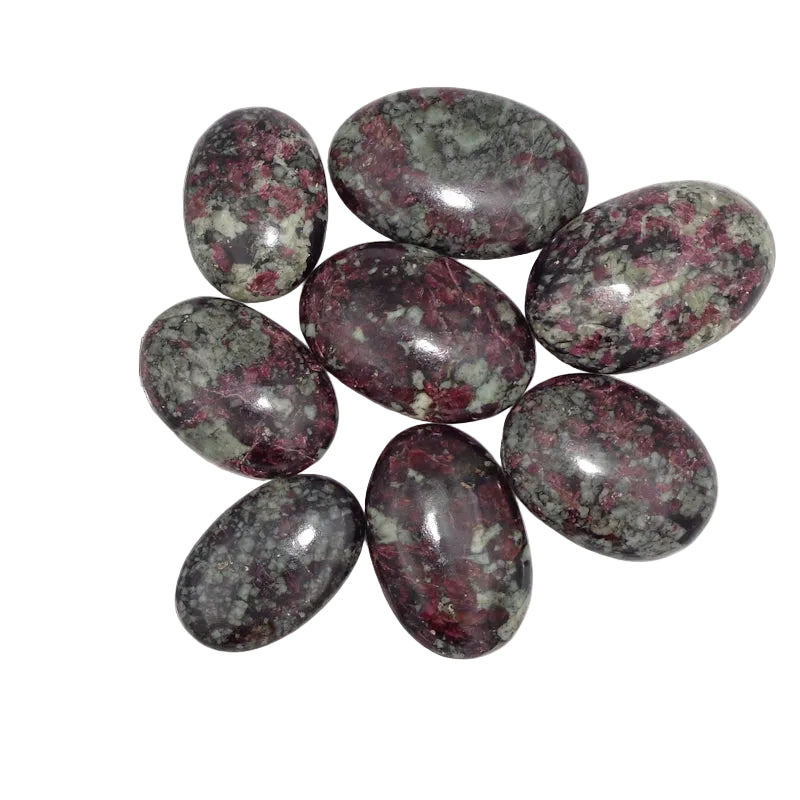 Oval-shaped marbled stones with a ruler for scale on a white background